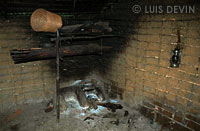 Interno di una capanna pigmea con fuoco e manufatti