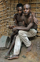 Pigmei Bakola-Bagyeli seduti davanti a una capanna